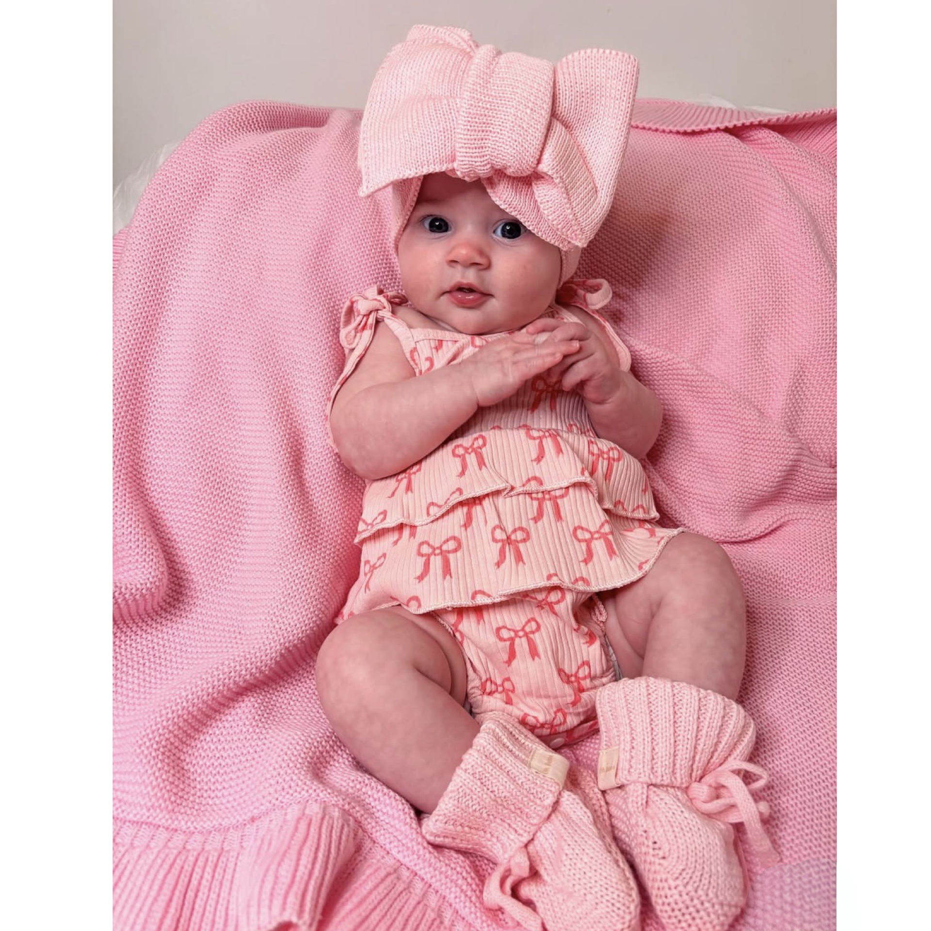 Newborn baby girl bows romper. Newborn pink knit booties and bow. Pink frill knit baby blanket