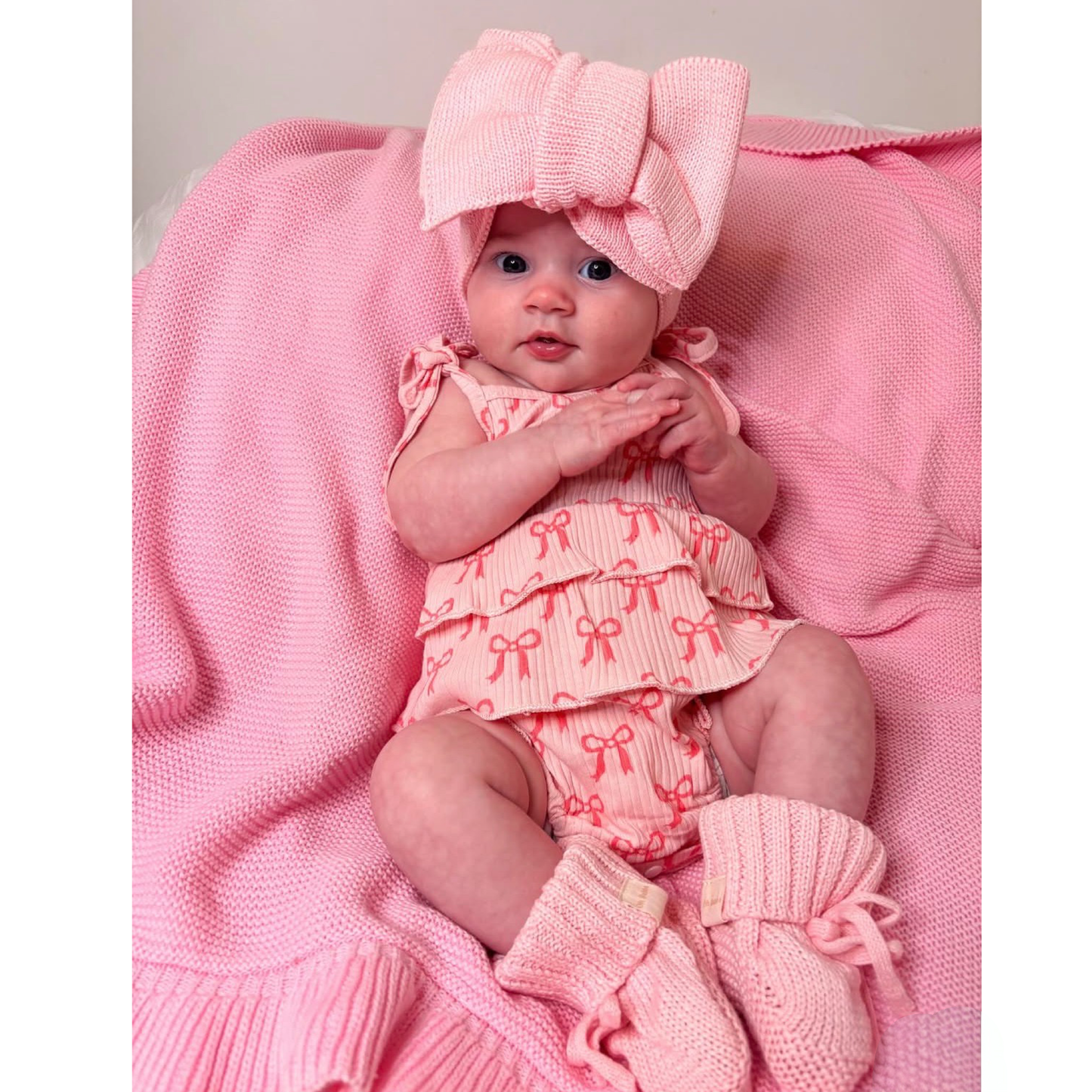 Newborn baby girl bows romper. Newborn pink knit booties and bow. Pink frill knit baby blanket